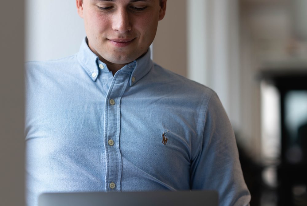 Medarbejder fra Capacit arbejder på computeren og smiler